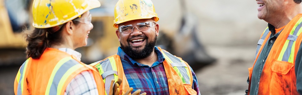 Three people in hard hats laughing together