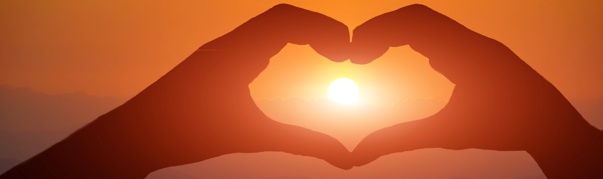Graphic showing hands making shape of a heart around the setting sun.
