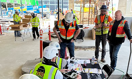 Group of men in hard hats talking at a work site.